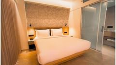 image featureing a plush double bed with bed side tables and a sleek wallpaper - biznotel by pride, motera